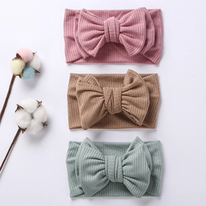 Three-piece set of ribbed knit baby headbands with large double bows in soft colors