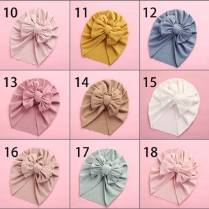 Detail view of baby turban headwraps showing nine assorted colors and ribbed fabric texture