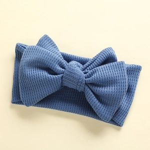 Detail of blue waffle texture knit headband for babies with large handmade DIY bow