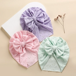 Detailed eyelet embroidery and bowknot design on pastel colored baby turban hats