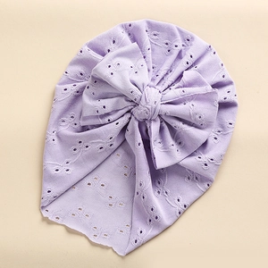 Close-up of light purple baby turban hat with delicate hollow lace and bow detail