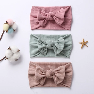 Three-pack of ribbed knit baby headbands with large bows in pink, mint, and brown