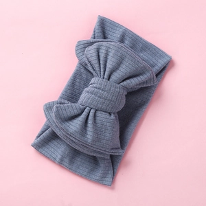Detailed texture of blue-gray knitted baby headband with a large layered bow knot