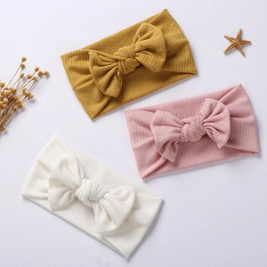 Three elastic knit baby headbands with bows in yellow, pink and white colors