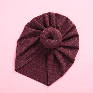 Detailed view of dark red knit baby turban hat featuring a signature doughnut knot design