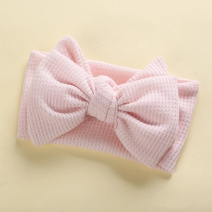Detailed view of pink waffle texture baby headband with large handmade bow knot decoration
