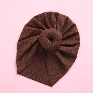 Close-up of baby turban hat with ribbed knit texture and 3D donut knot detail
