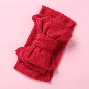 Detail of red ribbed knit baby headband featuring a large textured oversized bow