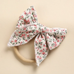 Dettaglio della fascia con fiocco in cotone a fiori e morbido nylon per neonati