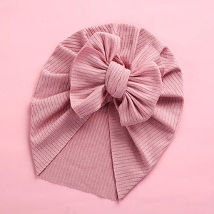 Detail of baby turban headwrap with large bow in soft ribbed dusty pink fabric