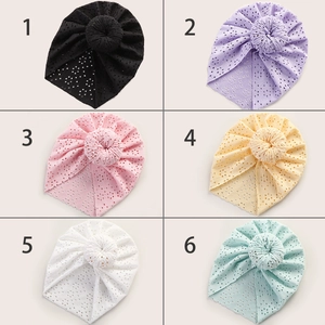 Detail view of baby lace hollow knit donut beanies in six vibrant colors