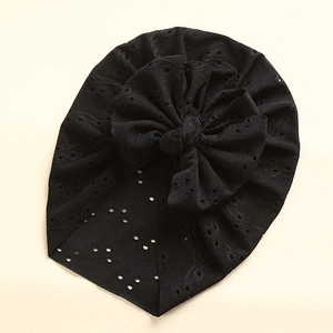Detail of black hollow-out embroidery baby turban with a large layered decorative bow