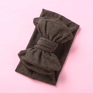 Close-up of baby ribbed knit headband with large double-layered bow in dark coffee brown color