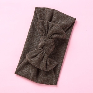 Detail of dark brown ribbed knit baby headband with a large stretch cotton bow