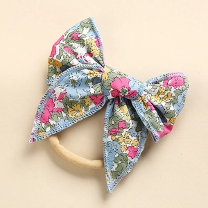 Dettaglio fiocco floreale in cotone con fascia in nylon morbido per neonata bambina