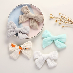 Détail de cinq nœuds papillon en mousseline de coton aux tons pastels et imprimé orange