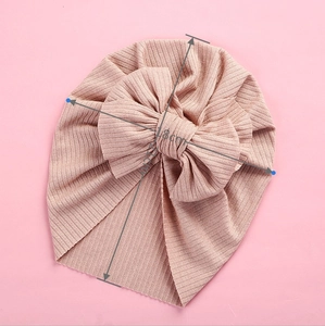 Pink ribbed baby turban hat with oversized bow detail showing 18cm width and 17cm height