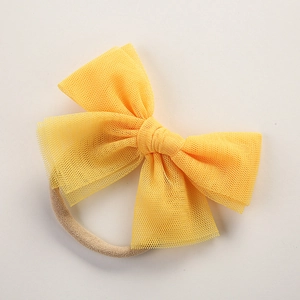 Detail of bright yellow mesh tulle bow and seamless nylon headband for newborns