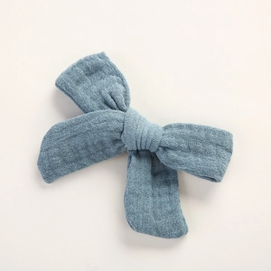 Détail de la pince à cheveux double nœud en mousseline de coton bleu Morandi doux