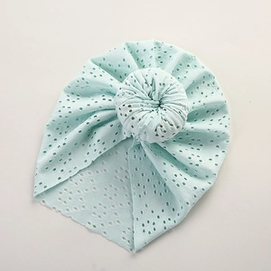 Detailed macro view of mint green hollow lace beanie with a stylish donut top knot