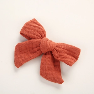 Détail du nœud papillon en coton mousseline rouge brique pour enfants et bébés