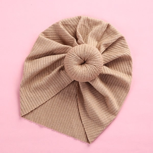 Close-up of baby beige ribbed knit turban hat featuring a soft donut knot detail