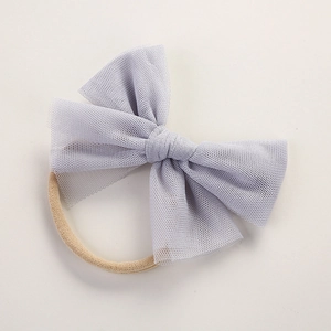 Detail of grey mesh tulle bow and soft nude nylon elastic headband for infants