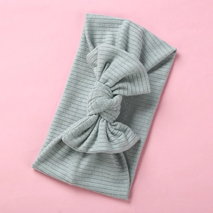 Detailed macro view of light gray ribbed fabric texture and large bow on baby headband
