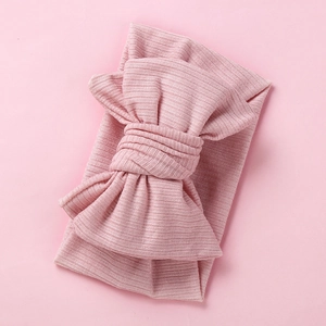 Detail of soft ribbed texture and oversized double layer bow on pink baby headband