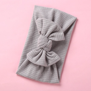 Close-up of a medium grey ribbed knit baby headband with a large decorative bow