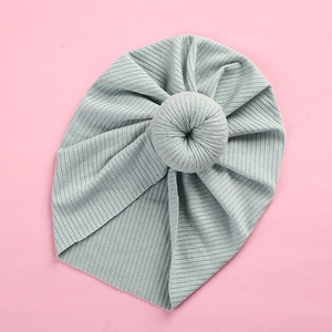 Detail of light blue baby turban hat with ribbed knit texture and donut knot design