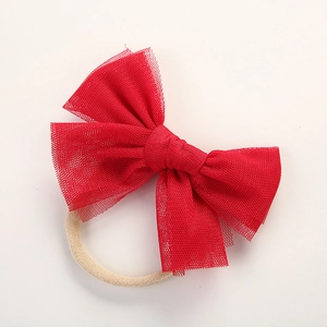 Detail view of the red mesh bow hairband showing soft nylon fabric and elastic texture