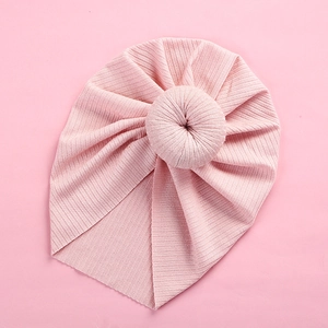 Close-up of pink ribbed knit baby turban hat with a signature donut knot detail