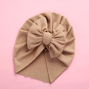 Detailed overhead shot of a khaki ribbed knit baby turban with a large soft bow decoration