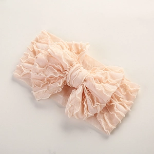 Détail d'un bandeau bébé rose pâle en tissu côtelé élastique avec nœud à volants