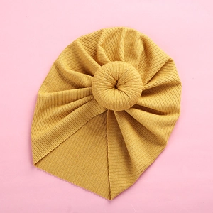 Detailed texture of yellow ribbed knit baby turban hat with a donut knot design