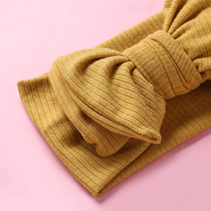 Ginger yellow ribbed knit baby headband featuring an oversized decorative bow accent