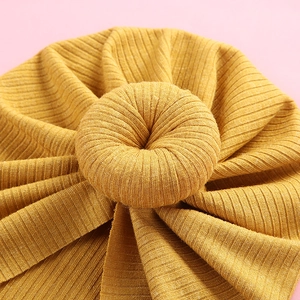 Ginger yellow ribbed knit baby turban hat with a sweet donut knot decoration for spring