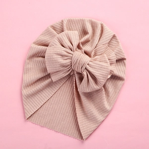 Close-up of the ribbed texture and large bow on this soft pink baby turban headwrap