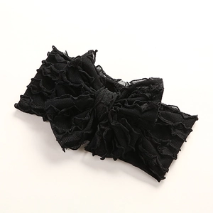 Détail d'un bandeau noir avec un nœud multicouche en maille fine et texture plissée