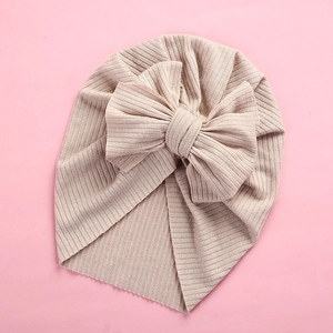 Detail of soft ribbed apricot baby turban hat with oversized stylish knot bow decoration