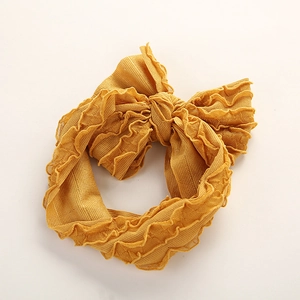 Vue détaillée du bandeau à nœud jaune moutarde avec une texture en tissu côtelé doux