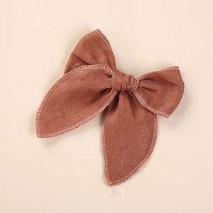 Gros plan du nœud papillon en lin marron montrant la couture fine brodée sur le bord