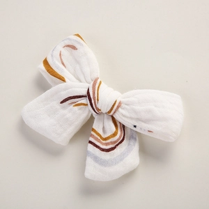 Détail de la pince à cheveux en gaze de coton avec des motifs arc-en-ciel pour bébés