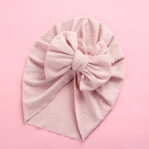 Detail of baby turban headwrap in pink ribbed knit fabric with a large soft bow