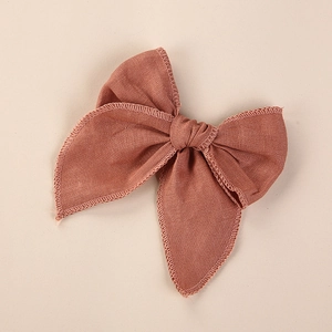 Détail du nœud papillon en lin terre cuite montrant la texture du tissu brodé