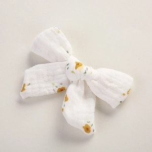 Détail de la barrette en mousseline de coton crème avec imprimé floral jaune et froissé