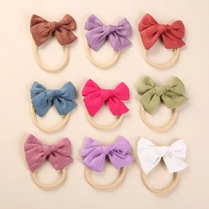 Set of 9 soft linen bow headbands for babies in assorted colors with nylon bands