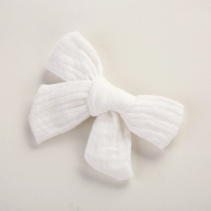 Détail de la texture en mousseline blanche et pince à cheveux nœud pour enfants