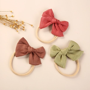 Three-piece set of linen baby bow headbands in rust red, dark brown, and bean green